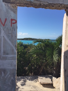 An abandoned building with graffiti and a view of Allen Cay in the the Bahamas.