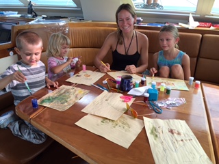 Kids with a Guest at the saloon table in the St Francis 50 catamaran, SV Aphrodite.