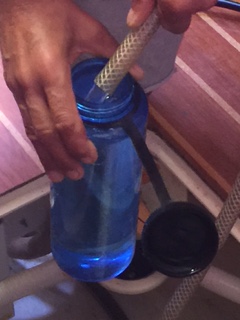 A Nalgene bottle being filled directly from our watermaker