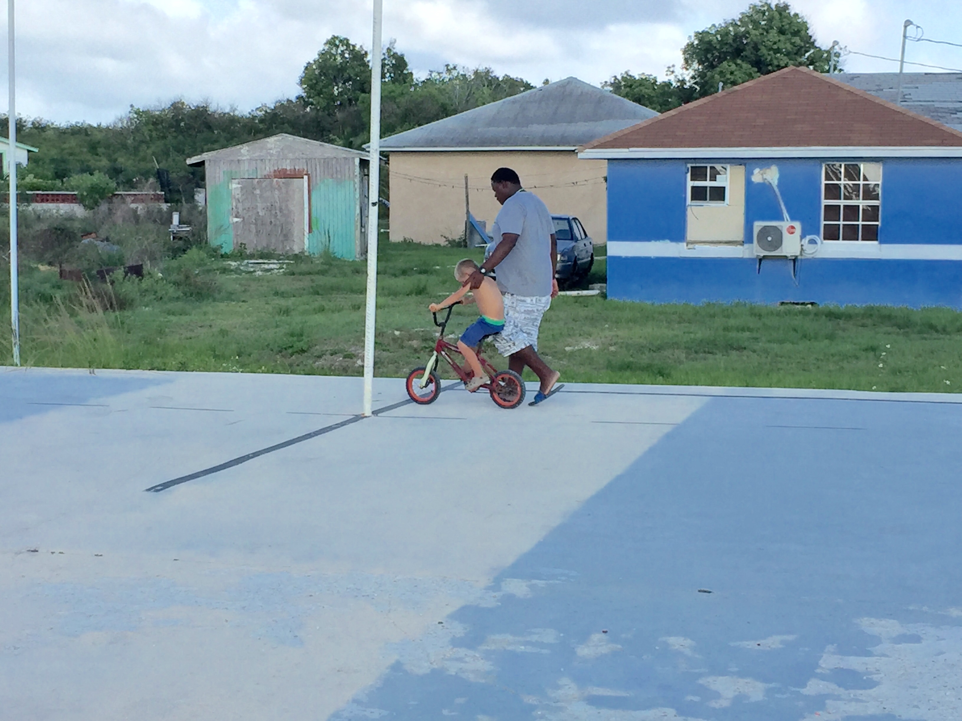 Henry, boat kid, of SV Aphrodite rides a bike in Abraham's Bay, Mayaguana