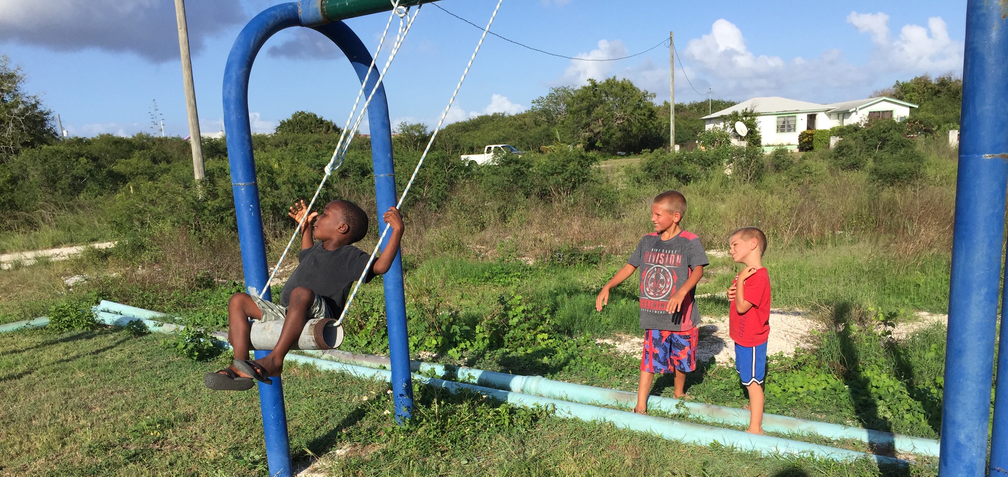 Shawnny of Abraham's Bay, Mayaguana with boys from SV Aphrodite, Henry and Paul on the swing that we made at the play park.