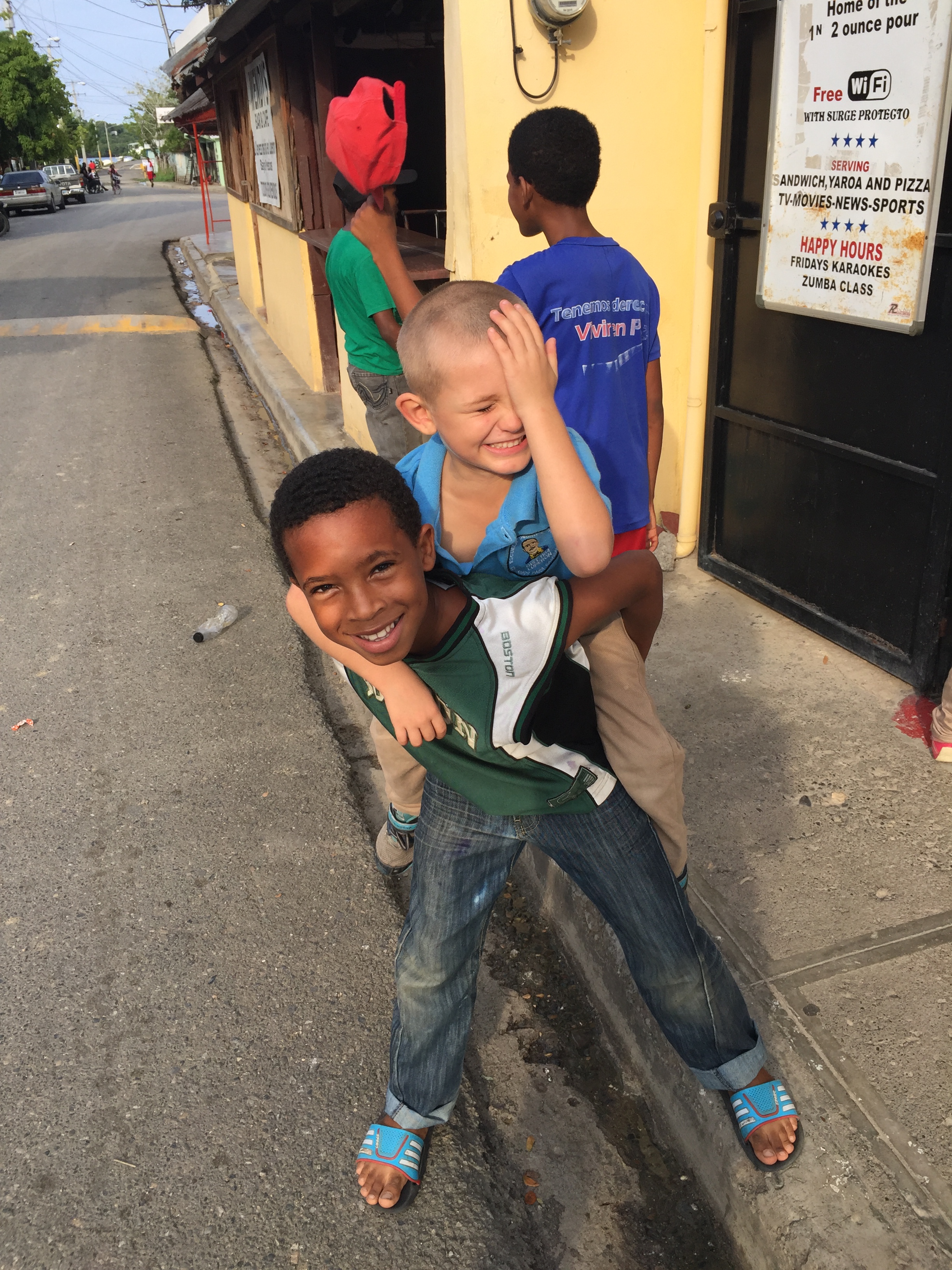 Henry and a local boy from Luperón, Dominican Republic on their way home from school walking past Wendy's bar, which is a popular cruisers' hangout