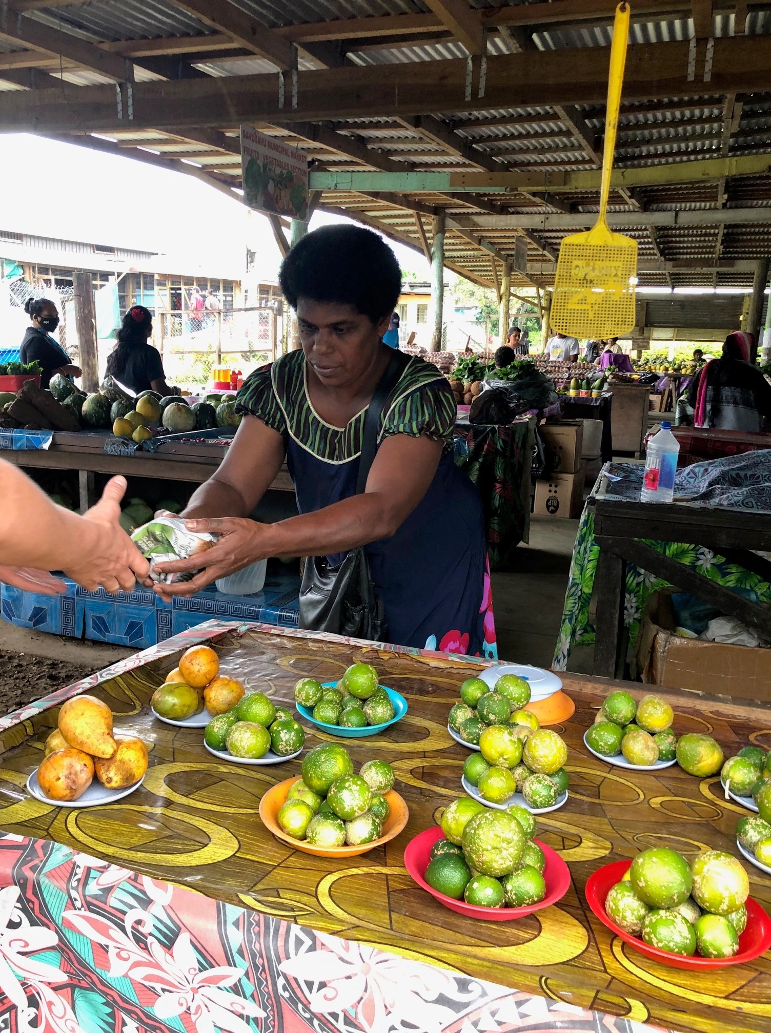 Woman selling green oranges in 'heaps' at the Savusavu Farmers market.