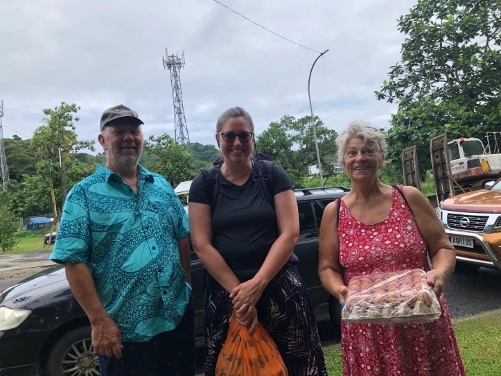 Lorraine Escher stands with fellow cruisers from Ottawa, Canada, Phil and Debra Perfitt. Debra is holding a flat of eggs. This couple calls themselves the Perfitts of the Pacific.
