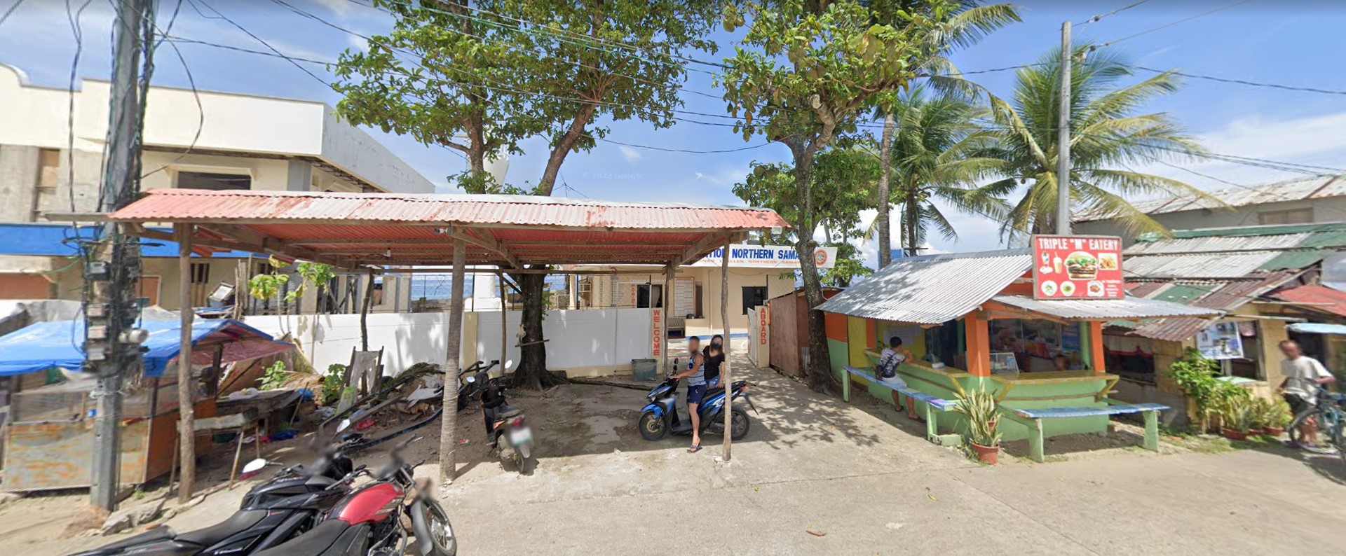 Coast Guard Sub-Station Allen in Northern Samar, Philippines, with the nearby Triple M Eatery and motorbikes parked outside