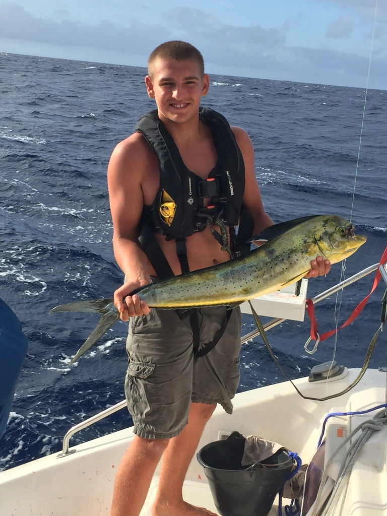 Paul holding a freshly caught mahi-mahi on the deck of SV Aphrodite while sailing through Micronesia