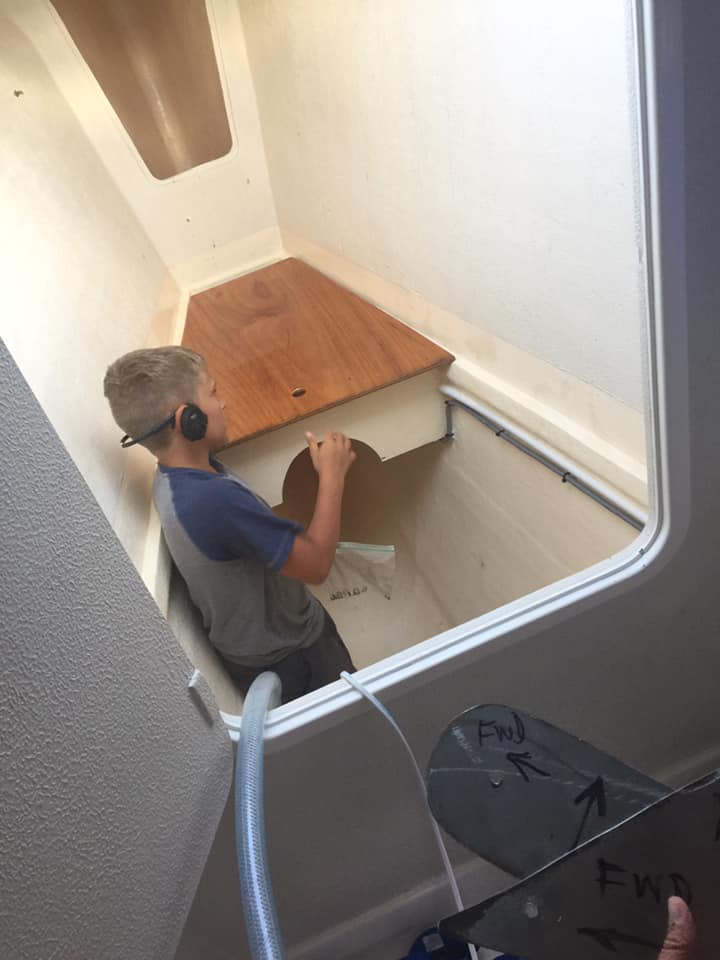 Paul, age 10, in the bow locker applying lock nuts