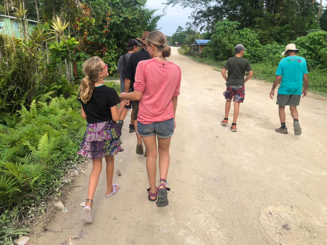 The SV Aphrodite family crew walks along a dirt road that used to transport solidiers of World War II in Munda, Solomon Islands.
