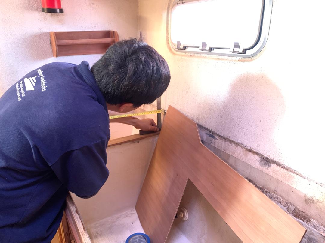 Chin of Eastbay Teakdecks shows a relaxed posture while measuring the galley-down of SV Aphrodite.