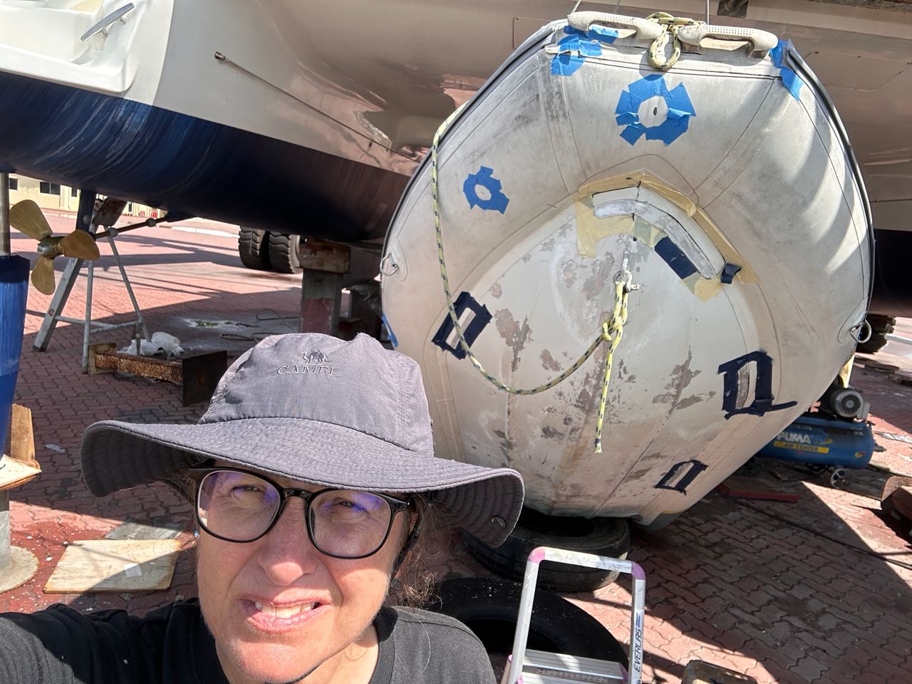 Blue tape on a hyalon Zar dinghy to prepare for a leak repair in Lunas Shipyard, Langkawi, Malaysia