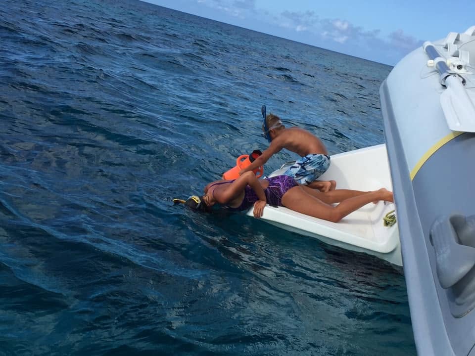 Elizabeth and Paul view a shark from the safety of our boat, SV Aphrodite in Rum Cay, Bahamas.