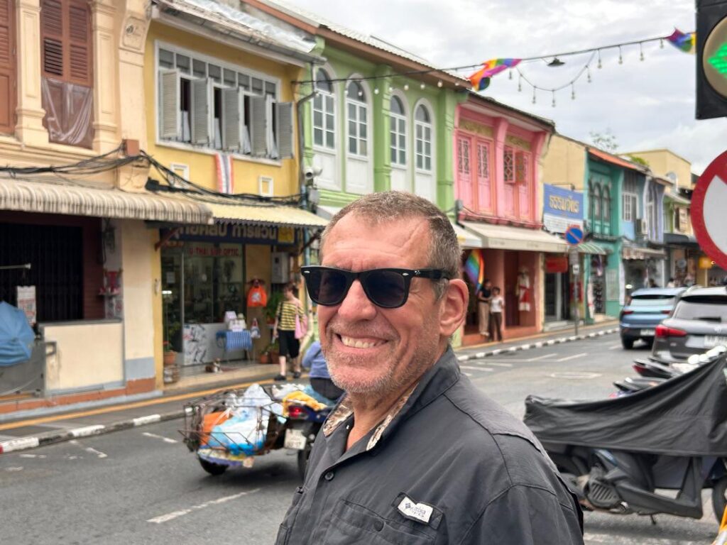 Rick of SV Aphrodite with colourful storefronts in Old Town Phuket, Thailand